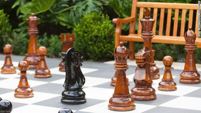 What Are Chess Pieces Made Of in Outdoor Sets? Giant wooden chess pieces arranged on an outdoor board.