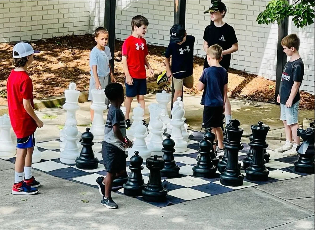 Photo children playing giant chess outdoors at school