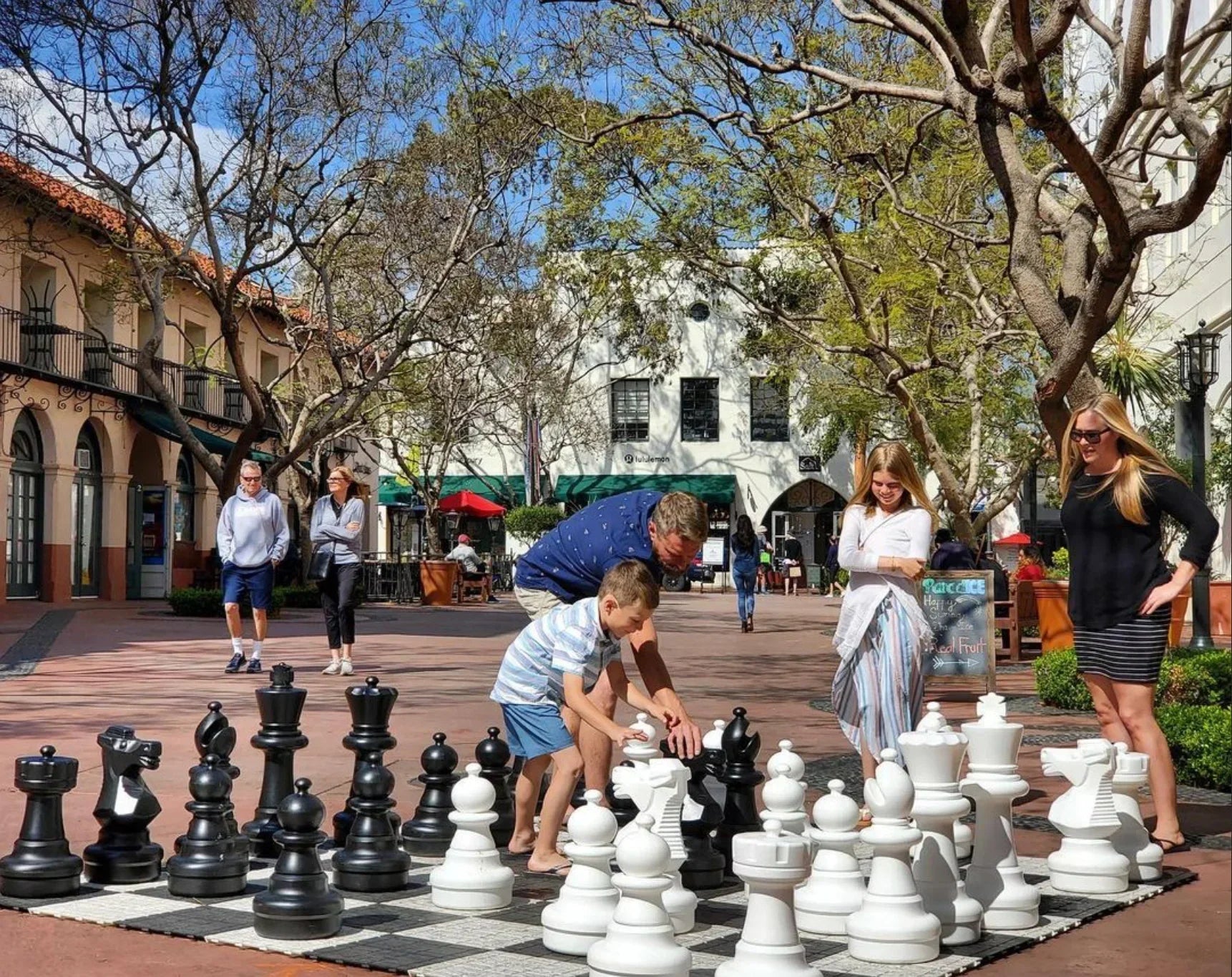 How to Play Giant Chess for Beginners - Children and adults enjoying a game of giant chess outdoors.