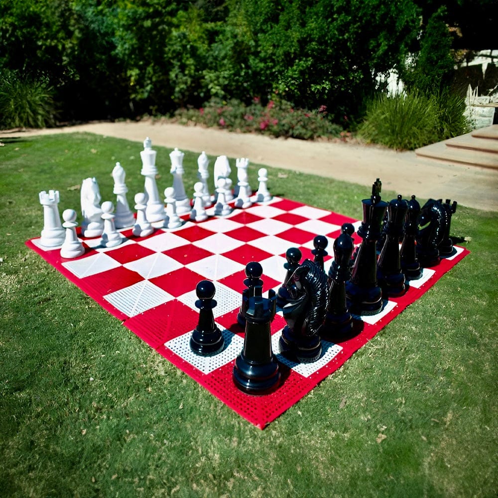 Two Foot Tall Fiberglass Giant Chess Sets displayed on a red and white chessboard in a garden.