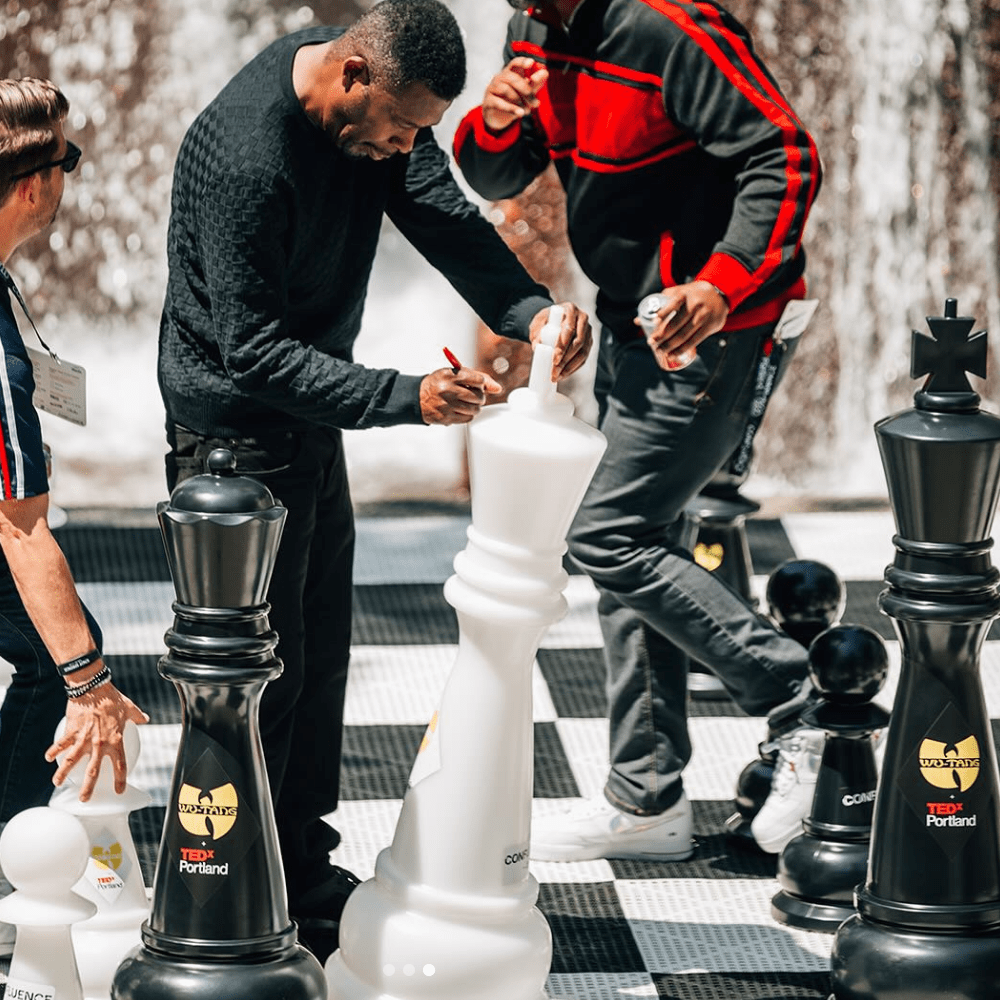 Four Foot Tall Personalized Giant Chess Sets being signed by players at an outdoor event.
