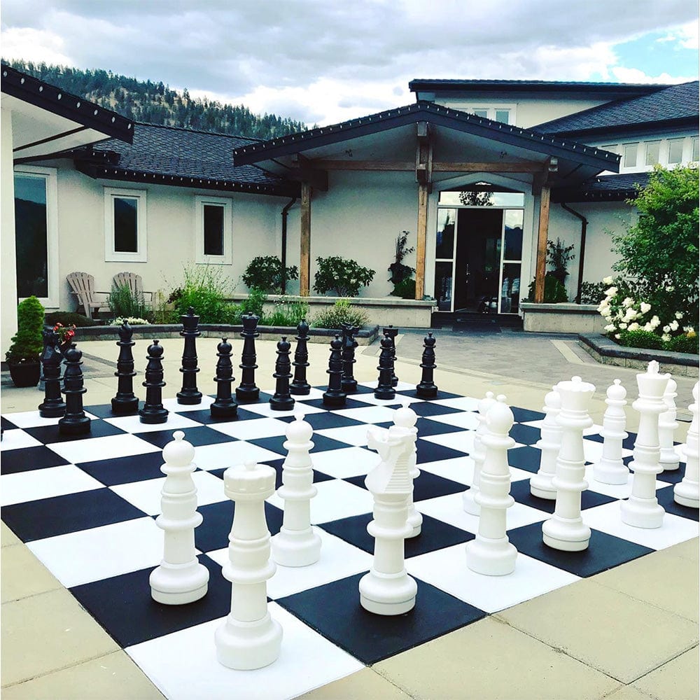 Three Foot Tall Plastic Giant Chess Sets displayed outdoors on a large checkered board.