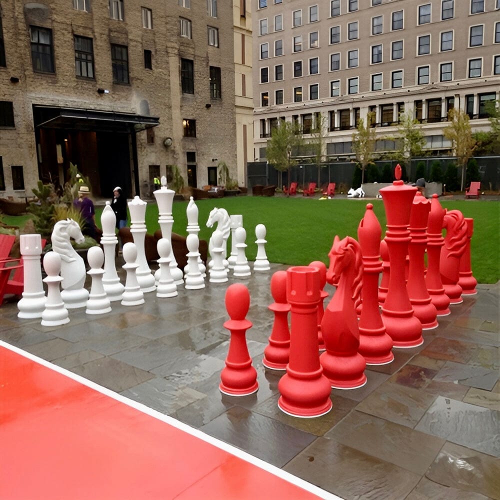 Six Foot Tall Personalized Giant Chess Sets displayed in a park with red and white pieces on a stone surface.