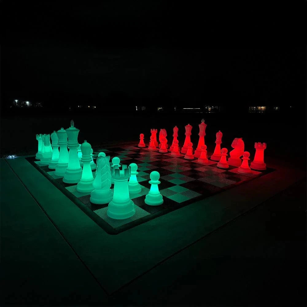 Glowing green and red chess set on a board at night